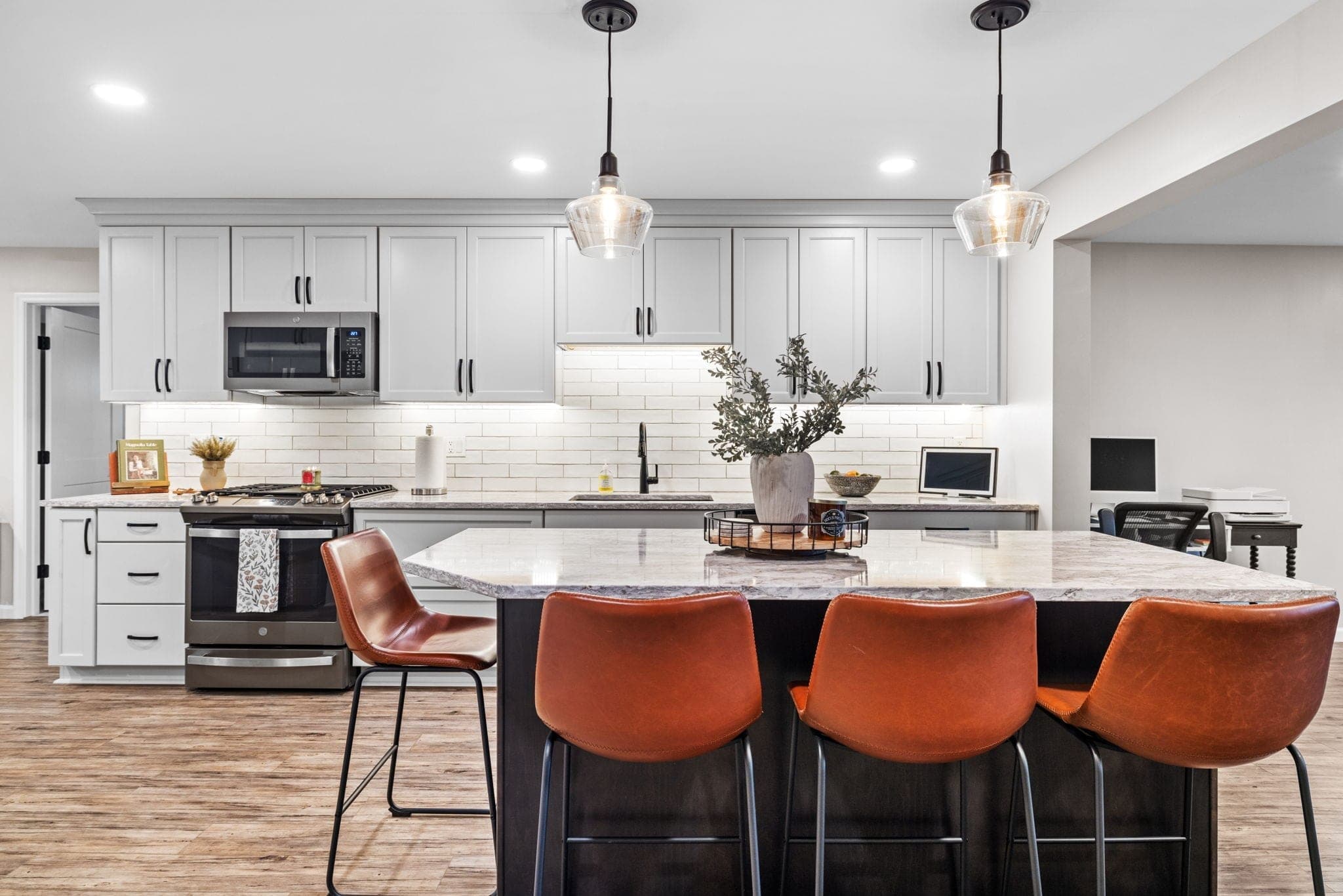 Renovated kitchen with gray cabinetry and island seating on Hereford Drive in Oakdale, PA, built by Integrated Contracting & Renovations